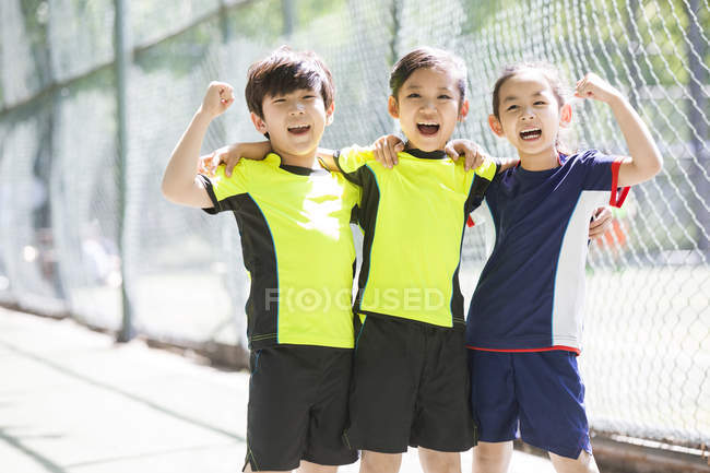 Enfants chinois en vêtements de sport acclamant — Photo de stock
