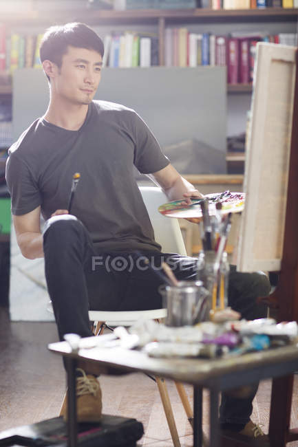 Asiatique mâle peintre travaillant dans art studio — Photo de stock