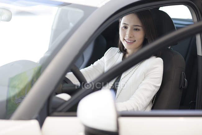 Chinesin sitzt in Auto auf Parkplatz — Stockfoto