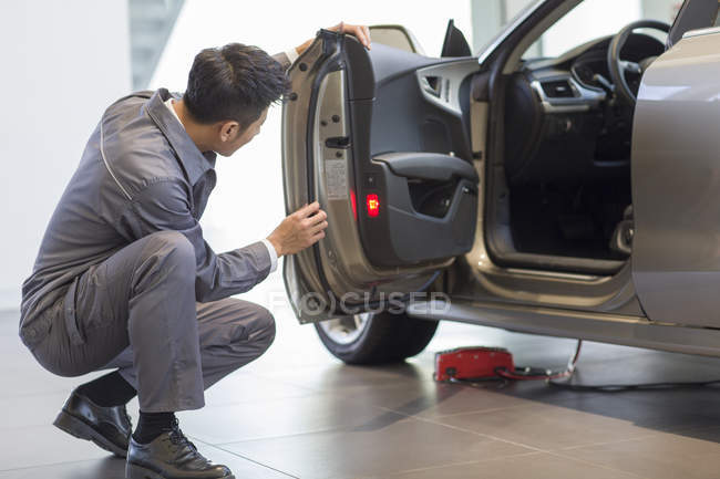 Mécanicien automobile chinois examinant la porte de voiture — Photo de stock