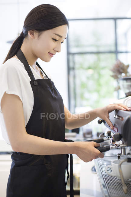 Chinese female barista making coffee — Stock Photo