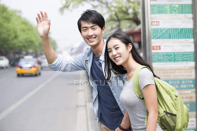 Chinesisches Paar wartet an Bushaltestelle — Stockfoto