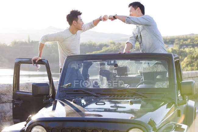 Chinese men fist bumping in car — Stock Photo