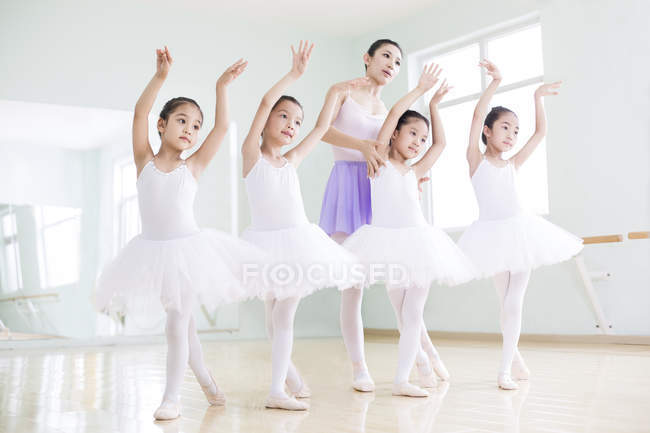 Chinese ballet instructor teaching girls in ballet studio — Stock Photo