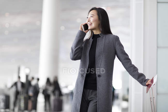 Femme asiatique parlant au téléphone à l'aéroport — Photo de stock