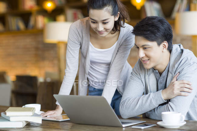 Китайська пара, використовуючи ноутбук разом в кафе — стокове фото