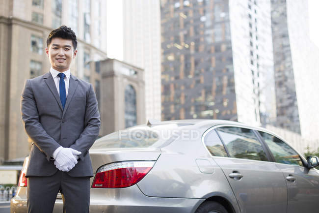Motorista chinês de pé ao lado do carro — Fotografia de Stock
