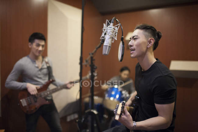 Китайская музыкальная группа записывает песню в студии — стоковое фото