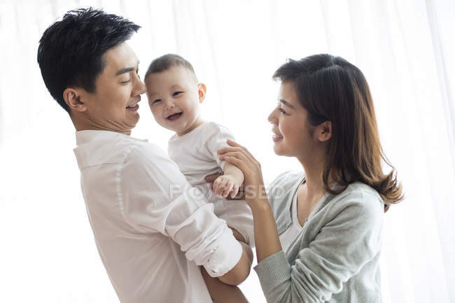 Padres chinos con niño sonriente - foto de stock
