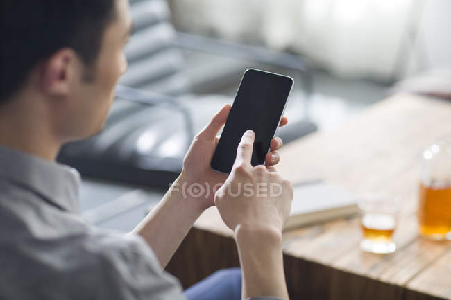 Close-up view of man using smartphone in office — Stock Photo