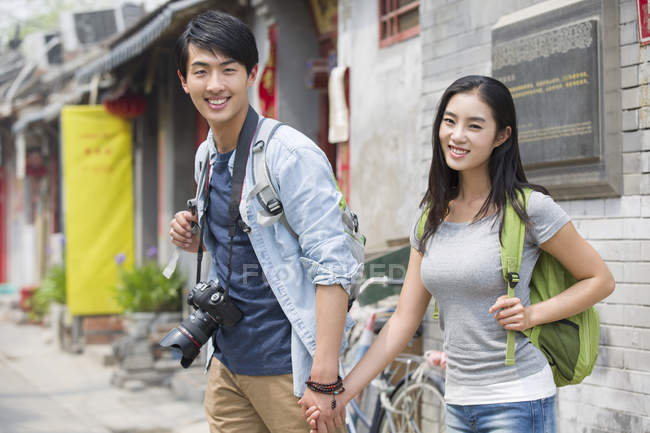 Китайская пара, стоящая на улице в Пекине с камерой — стоковое фото