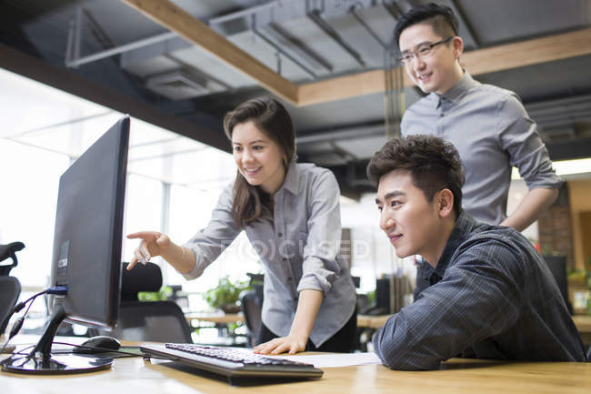 Китайские офисные работники используют компьютер в офисе — стоковое фото