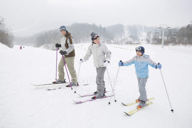 Китайская семья с сыном катается на лыжах на горнолыжном курорте — стоковое фото