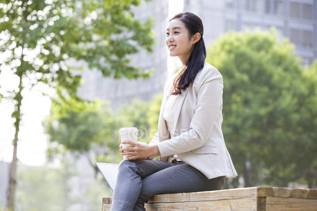 Chinesische Geschäftsfrau mit Kaffeetasse auf der Straße — Stockfoto