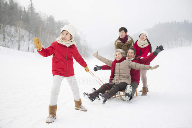 Китайські родини трьох поколінь позують з сани на снігу — стокове фото