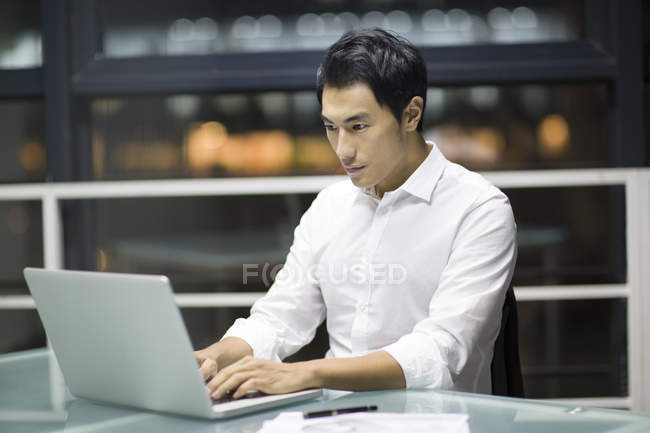 Empresário chinês trabalhando até tarde no escritório — Fotografia de Stock