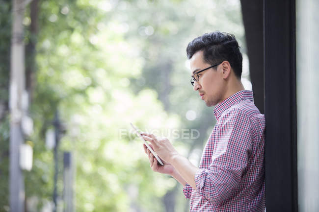 Asiatique homme en utilisant tablette numérique sur la rue — Photo de stock