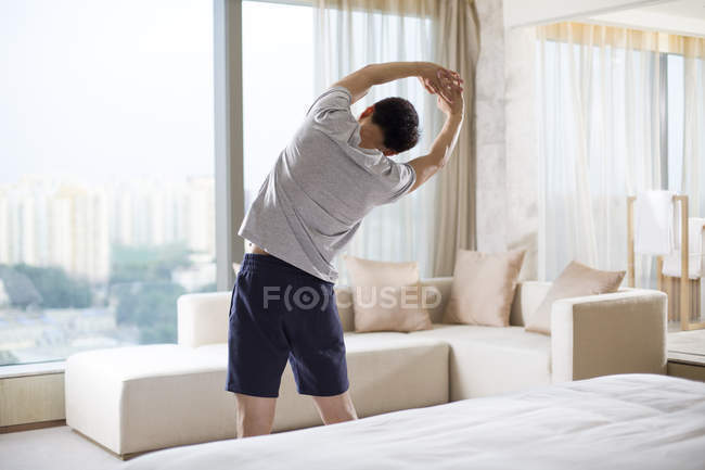 Молодой человек занимается спортом в гостиной — стоковое фото