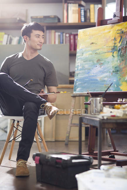 Asiático pintor masculino trabalhando no estúdio de arte — Fotografia de Stock