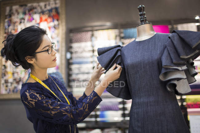 Chinesische Modedesignerin arbeitet an Kleid im Geschäft — Stockfoto