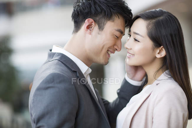 Chinese couple standing face to face and smiling — Stock Photo