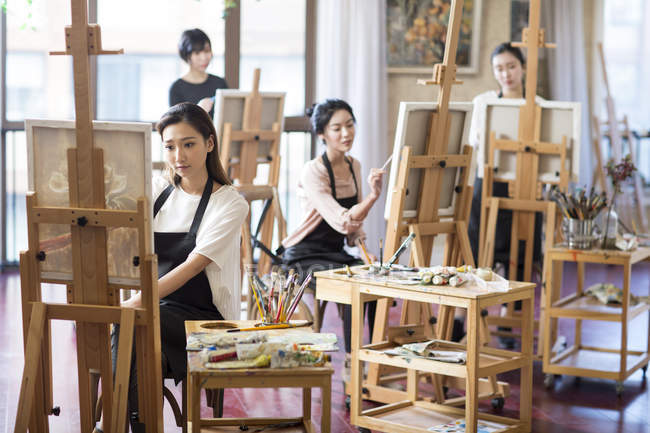 Mujeres asiáticas pintando en estudio de arte - foto de stock