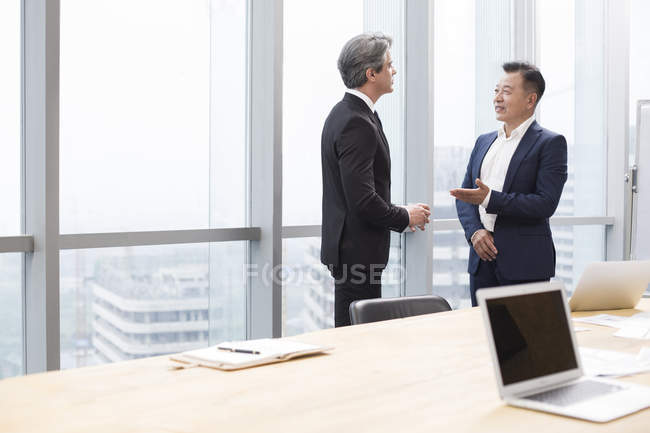 Бізнесмени розмовляють в кімнаті для переговорів — стокове фото