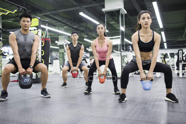 Asiáticos adultos trabajando con entrenador en gimnasio - foto de stock