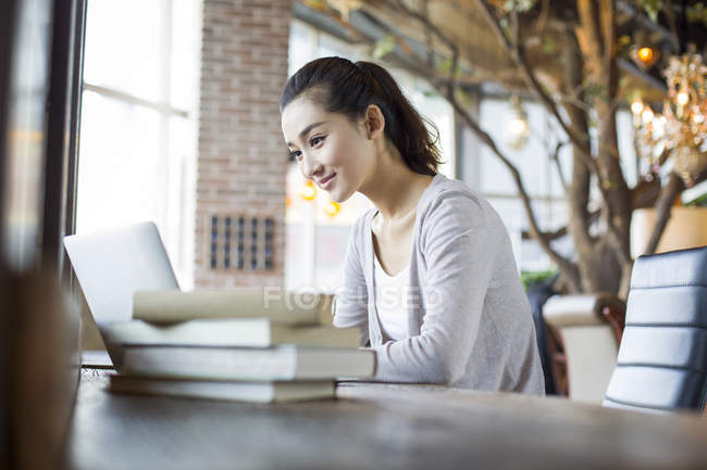 Mulher chinesa estudando com laptop no café — Fotografia de Stock