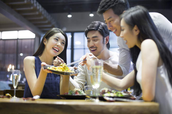Amis asiatiques partageant le repas au restaurant — Photo de stock