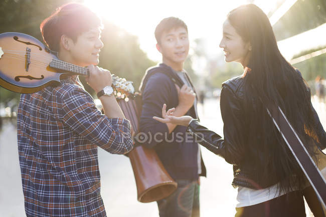 Chinese friends holding musical instruments, rear view — Stock Photo