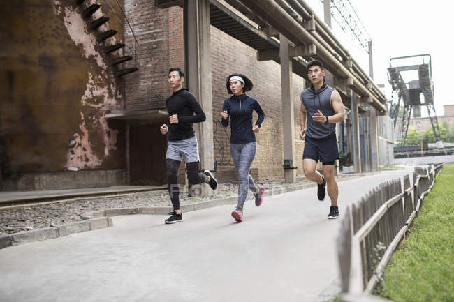 Atletas chinos corriendo en la calle - foto de stock