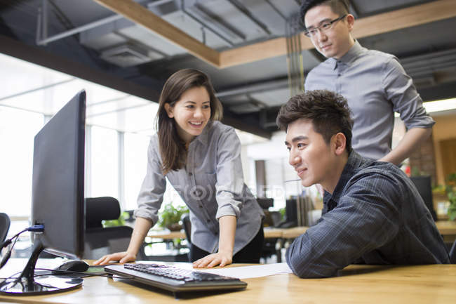 Chinese office workers talking in office — Stock Photo