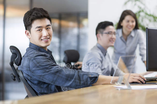 Китайские офисные работники сидят в офисе — стоковое фото