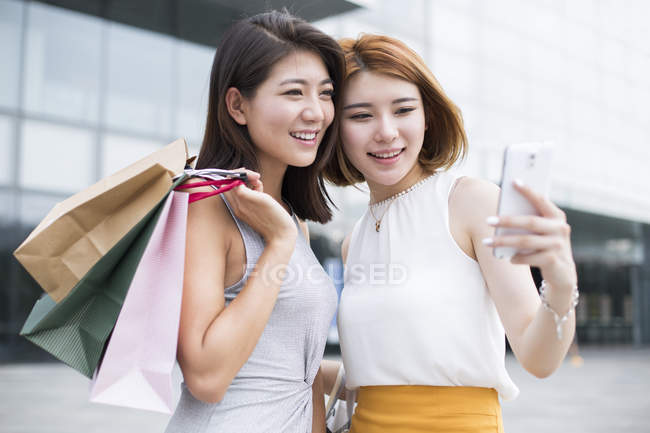 Amigos do sexo feminino tomando selfie durante as compras — Fotografia de Stock
