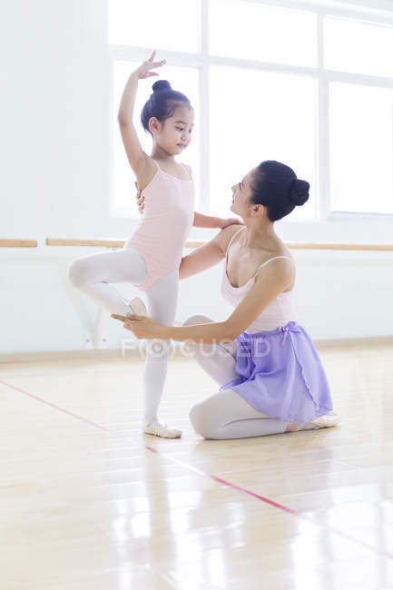 Little ballet dancer exercising with instructor in ballet studio — Stock Photo