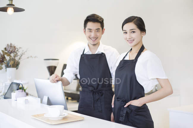 Pareja china trabajando en una cafetería - foto de stock