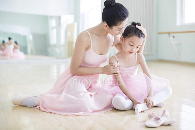 Professeur de ballet chinois et fille fatiguée assise dans un studio de ballet — Photo de stock