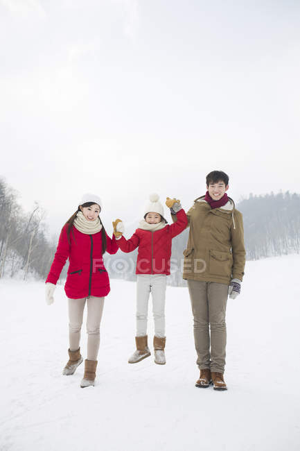Chinese family with daughter posing on snow — Stock Photo