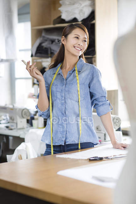 Китаянка модельер стоя за столом в студии — стоковое фото