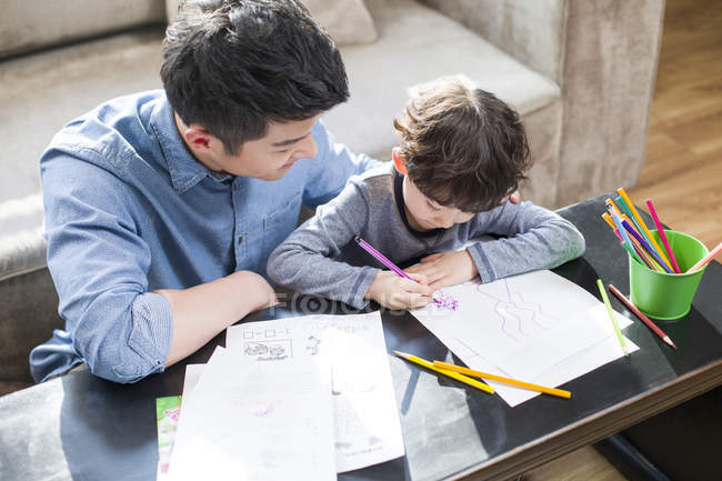 Отец помогает сыну с домашней работой — стоковое фото