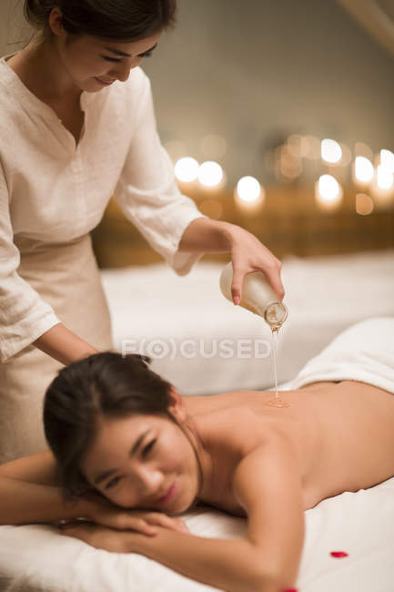 Young Chinese woman receiving massage at spa center — Stock Photo