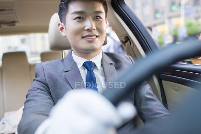 Sorridente cinese autista guida auto — Foto stock