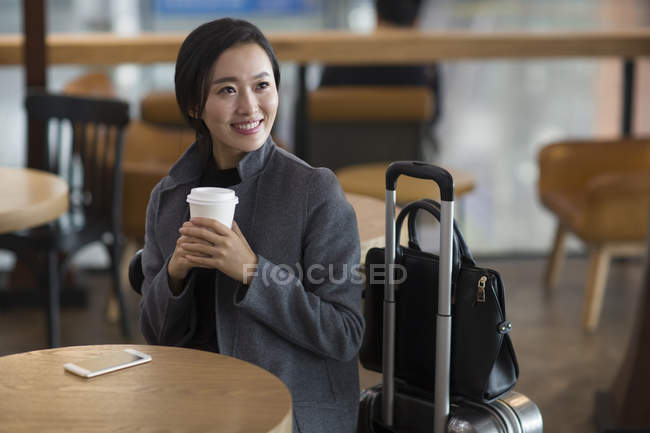 Азіатський жінка очікування в аеропорту з кавою — стокове фото