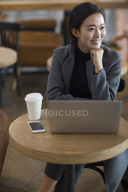 Donna asiatica in attesa in aeroporto con caffè e laptop — Foto stock