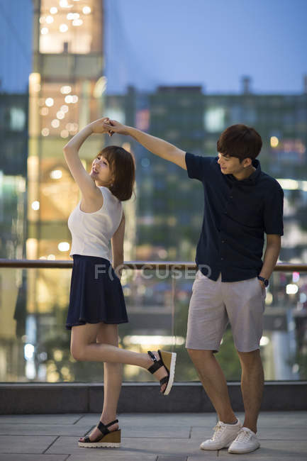 Young Chinese couple dancing on building terrace — Stock Photo