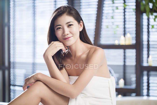 Young Chinese woman wrapped in towel looking in camera — Stock Photo