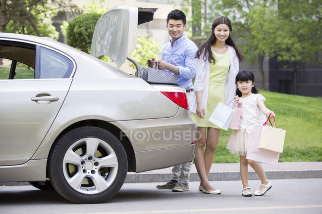 Famiglia cinese che prende borse della spesa dal bagagliaio dell'auto — Foto stock