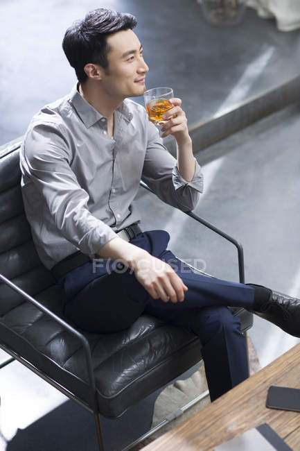 Hombre asiático disfrutando de bebida alcohólica - foto de stock