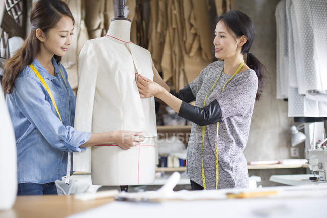 Chinese female fashion designers working in studio — Stock Photo